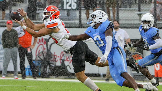 Nov 11, 2023; Orlando, Florida, USA; UCF Knights linebacker Jason Johnson (0) breaks up a pass against Oklahoma State Cowboys tight end Josiah Johnson (16) during the second quarter at FBC Mortgage Stadium. Mandatory Credit: Mike Watters-USA TODAY Sports